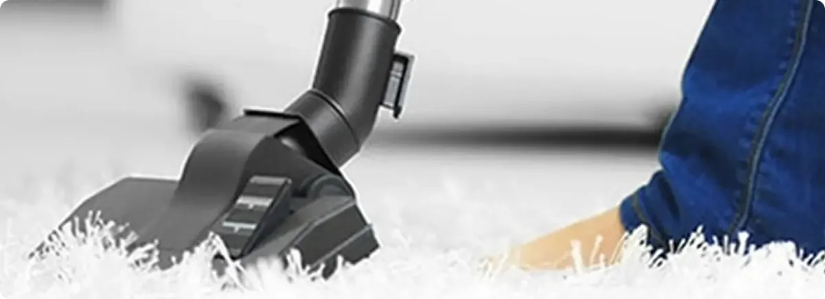 Close-up of a professional vacuuming a white carpet in Clarkston.